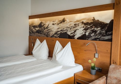 Gemütliches Bett mit Foto von Bergen über dem Bett