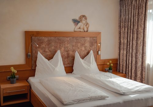 Doppelbett mit Engel darüber