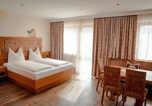 Doppelzimmer mit Tisch, Stühlen und Eckbank