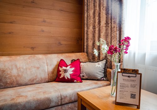 Gemütliche Sofaecke mit Dekokissen und Blumen