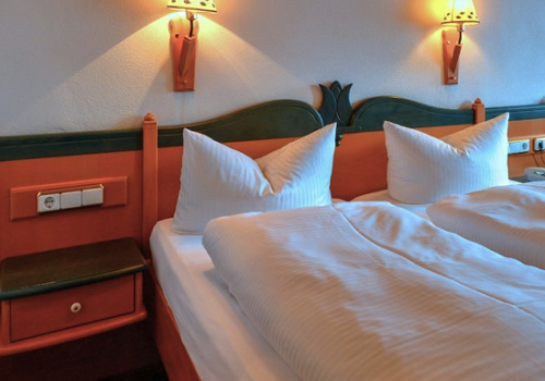 Gemütliches Doppelbett mit zwei Lampen über dem Bett