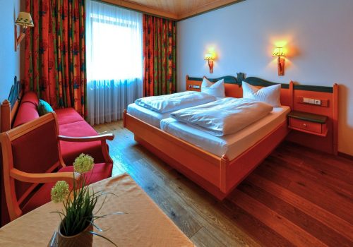 Doppelzimmer mit großem Bett und Sitzmöglichkeiten